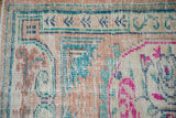 Distressed texture on the geometric plant border of a vintage Turkish rug in teal and sandalwood.