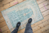 Distressed Turkish Oushak prayer rug showing its soft, worn texture in ocean green and cream.