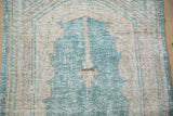 Close-up of the distressed prayer niche and lantern motif in ocean green and cream.