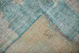 Corner detail of a vintage Oushak rug, revealing the hand-knotted foundation and secured blue selvage.
