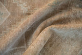 Distressed vintage Oushak rug texture showing even wear, abrashed ground, and faint geometric pattern.