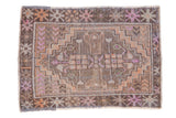 Vintage distressed Oushak rug, stepped medallion, primitive floral border, faded rainbow hues.