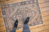 Distressed Oushak rug featuring stepped medallion, textured pile, and faded tangerine with soft violet hues.