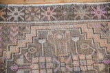 Distressed texture and primitive starburst floral border on vintage Oushak rug.
