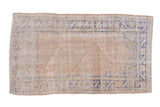 Distressed Vintage Oushak rug with a pale sand field and cobalt blue prayer motif.