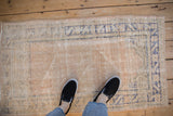 Distressed vintage Oushak rug with worn pile texture and faded blue border design.