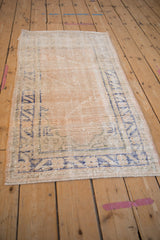 Worn pile texture of distressed Oushak rug with cobalt blue meandering vine border.