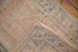 Distressed Oushak rug showing worn, pale sand pile and geometric patterns in blue, green on reverse.