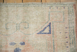 Worn, low pile and visible knot heads on the corner of a vintage Oushak rug.