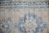 Distressed Oushak rug pile with wear to knot heads and foundation, beige and dusty blue.