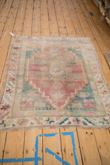 Distressed vintage Oushak rug border with serrated leaves, pink and turquoise floral motifs.