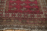 Anatolian rug's brown checkered pound border motif with deep raspberry field and fringe.