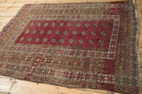 Deep raspberry red Bokhara gul motifs meet patterned borders with ram's horn designs and heavy abrashes.