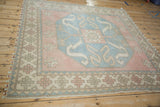 Braided cherry red and pale green fringe with geometric border on a vintage Oushak.