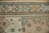 Geometric starburst florals and a meandering vine border on a distressed vintage Oushak rug.