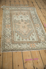 Angled view of a vintage distressed Oushak rug, showing its even wear and soft color palette.