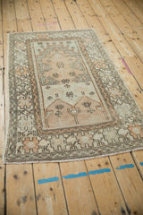 Angled perspective of a vintage Oushak rug showing the time-softened texture of its prayer design.