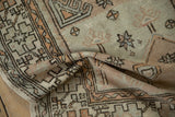 A fold in the vintage Oushak rug reveals the texture of the low pile and even wear.