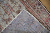 Distressed Oushak rug showing worn pile, blue foundation, and intact cream side cord.