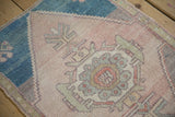 Distressed texture and geometric patterns in blush, dusty teal, and mauve on vintage Oushak rug.