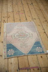 Patinaed Oushak rug detail: mauve, blush, teal geometric spandrel and finials.