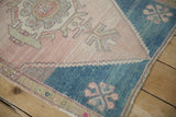 Geometric spandrel detail of the distressed vintage Oushak rug with dusty teal and blush tones.