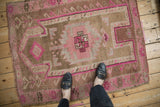 Distressed Kars rug features worn texture, faded pink-brown hues, and serrated palmettes.