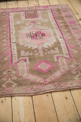 Distressed vintage Kars rug close-up showing worn magenta, brown serrated palmette pattern.