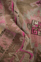 Distressed pile texture of vintage Turkish Kars rug with pink, magenta, and coffee brown tones.