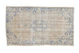 Distressed vintage Oushak rug with faded blue medallion on cream, 2'7