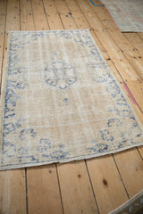 Vintage Distressed Oushak rug showcasing faded cream, soft blue motifs, and textural wear.