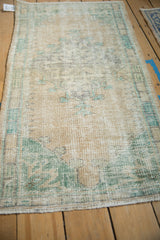 Distressed Oushak rug texture with worn cream pile and faded ocean green accents.