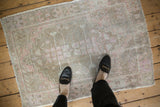 Soft, distressed pile texture of a vintage Oushak rug in beige, pink, and silver.