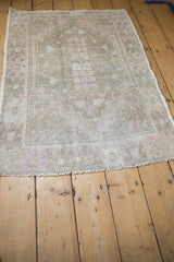 Worn texture and faded pink motifs in a distressed vintage Oushak rug's border.