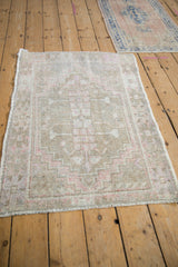 Intact side cord selvage on a distressed vintage Oushak rug with beige and pink.