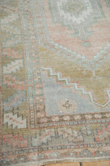 Distressed Oushak rug corner with serrated stepped spandrel in muted bronze and dusty rose.