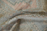 Distressed vintage Oushak rug texture with muted dusty rose, pale bronze, slate blue palette.