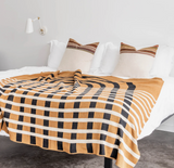 Eco-Friendly Blanket knit with modern gold, black, and white arched geometric pattern.