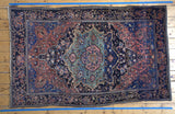 Antique Sarouk rug bottom corner, displaying ornate navy floral border and rich royal blue field.