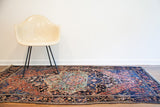 Antique Persian Farahan Sarouk rug displaying its irregular shape and striking blue-green abrash.