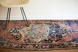 Fine patterns and strong blue-green abrash defining the antique Farahan Sarouk rug's medallion.