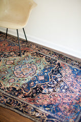 Traditional Persian Farahan Sarouk rug showing strong abrash in blue and seafoam green medallion.