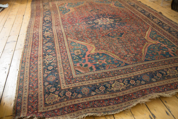 Angled corner view of an antique Persian rug highlighting the intricate spandrels and borders.