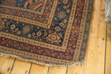 Detailed view of the worn corner and multi-layered border on a vintage Persian Bijar rug.