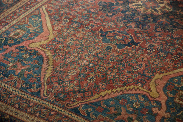 Detailed view of the worn wool pile and arabesque corner detail on an antique Persian Bijar rug.