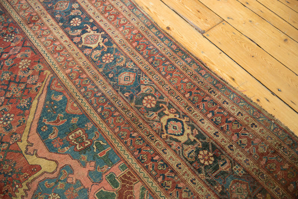Angled view of the corner spandrel and intricate striped borders on a Persian carpet.