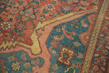 Corner detail of an antique Persian rug with stylized bird motifs in a blue and red spandrel.