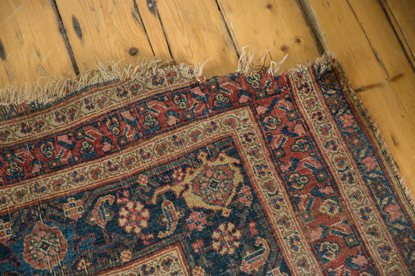 Detail of worn corner and frayed selvage on an antique Persian Bijar area rug.