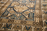 Detail of the soft, hand-knotted pile and geometric corner motifs on an antique Caucasian rug.