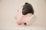 Side profile of a mid-century ceramic head showing the raw, broken base and glossy black hair.